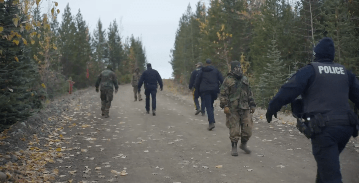 Physically trying to block the RCMP wearing camouflage in full breach of the Supreme Court Injunction. Physically trying to block the RCMP wearing camouflage in full breach of the Supreme Court Injunction.